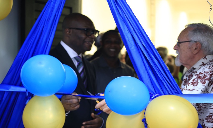 Prof. Dan Ofori assisting Prof. John Collins (Right) to cut the ribbon.